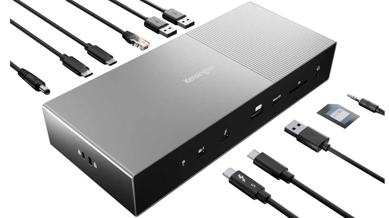 Silver multi-port docking station with various cables including USB, ethernet, charging ports, and memory card slots, laid out around it.