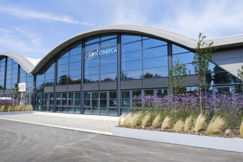 Curved building with glass windows and flowers out the front