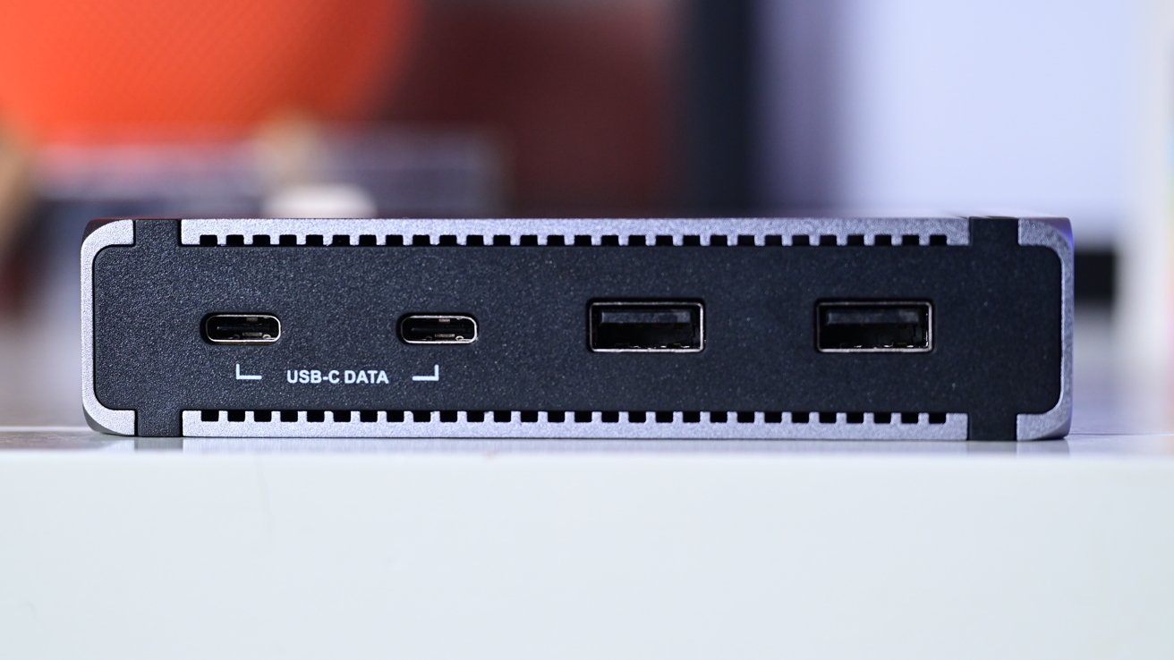 A close-up of a device showing two USB-C ports labeled for data and two standard USB ports, on a black and grey background.